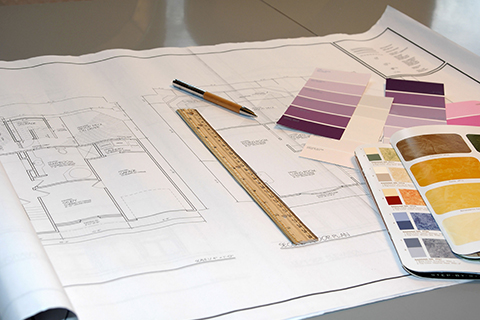 Drafting material including a ruler, pencil, and swatches for a floor plan